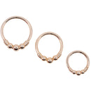 Three rose gold seam rings in different diameters. Each ring has the decorative portion of beads and wire.