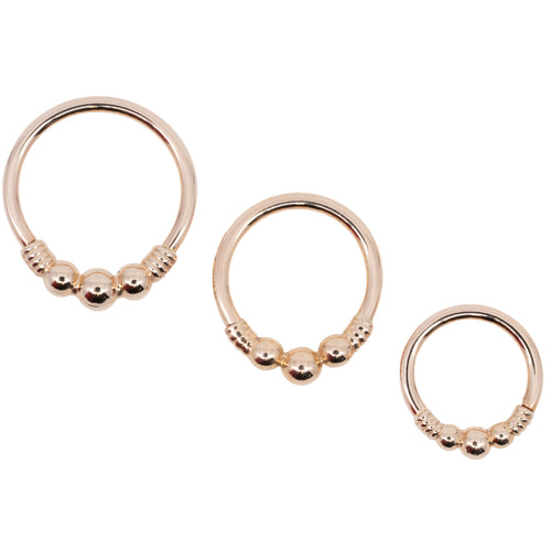 Three rose gold seam rings in different diameters. Each ring has the decorative portion of beads and wire.