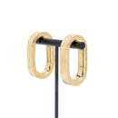A pair of yellow gold plated weights in an oval shape with a laser etched pattern on the outside.