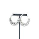 A pair of silver hoop earrings with petal details.