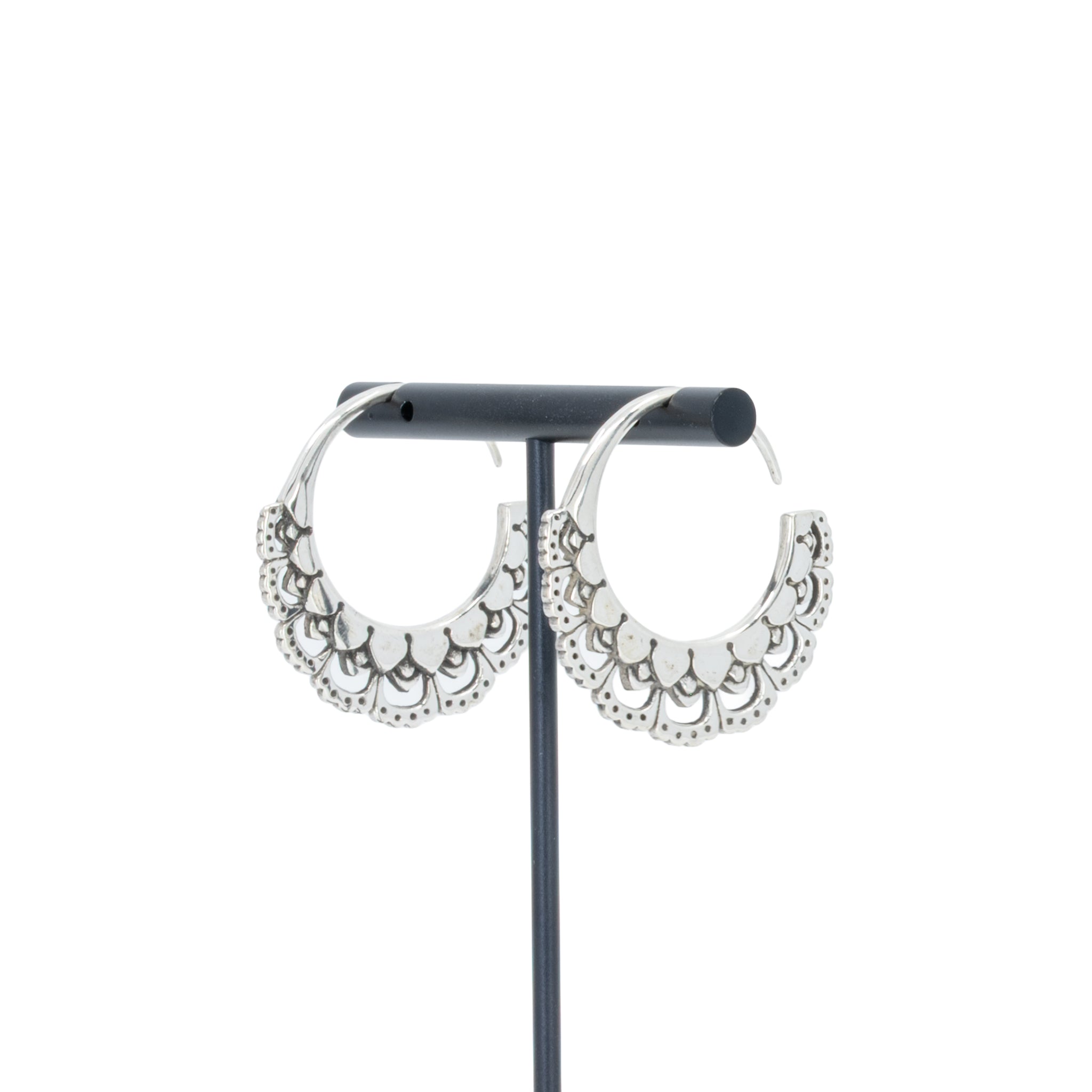 A pair of silver hoop earrings with petal details.