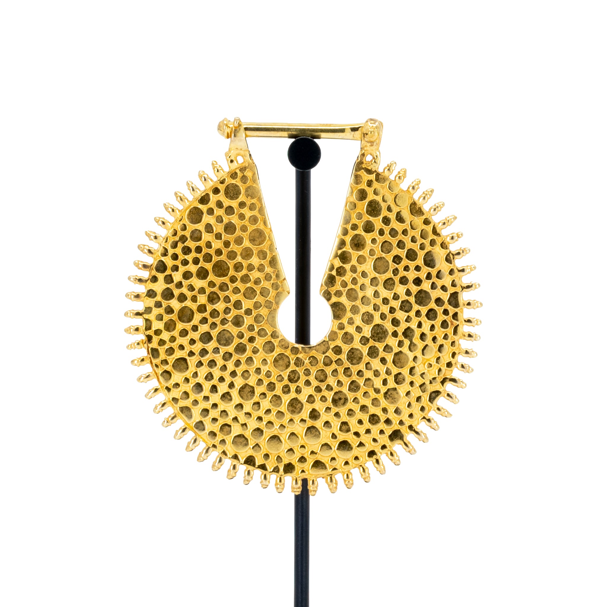 A large yellow gold weight with a  textured dotted surface and scalloped edge.