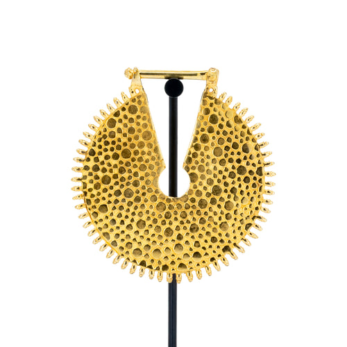 A large yellow gold weight with a  textured dotted surface and scalloped edge.