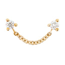 Two yellow gold push pin earrings with prong set round white diamonds connected by a 1/2 inch yellow gold chain.