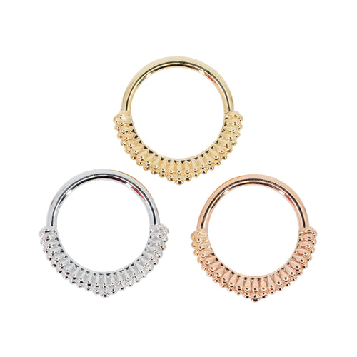 Three seam rings with a geometric decorative portion created with a rows of solid small teardrops, coming to a point in the center. One yellow gold, one white gold, and one rose gold.