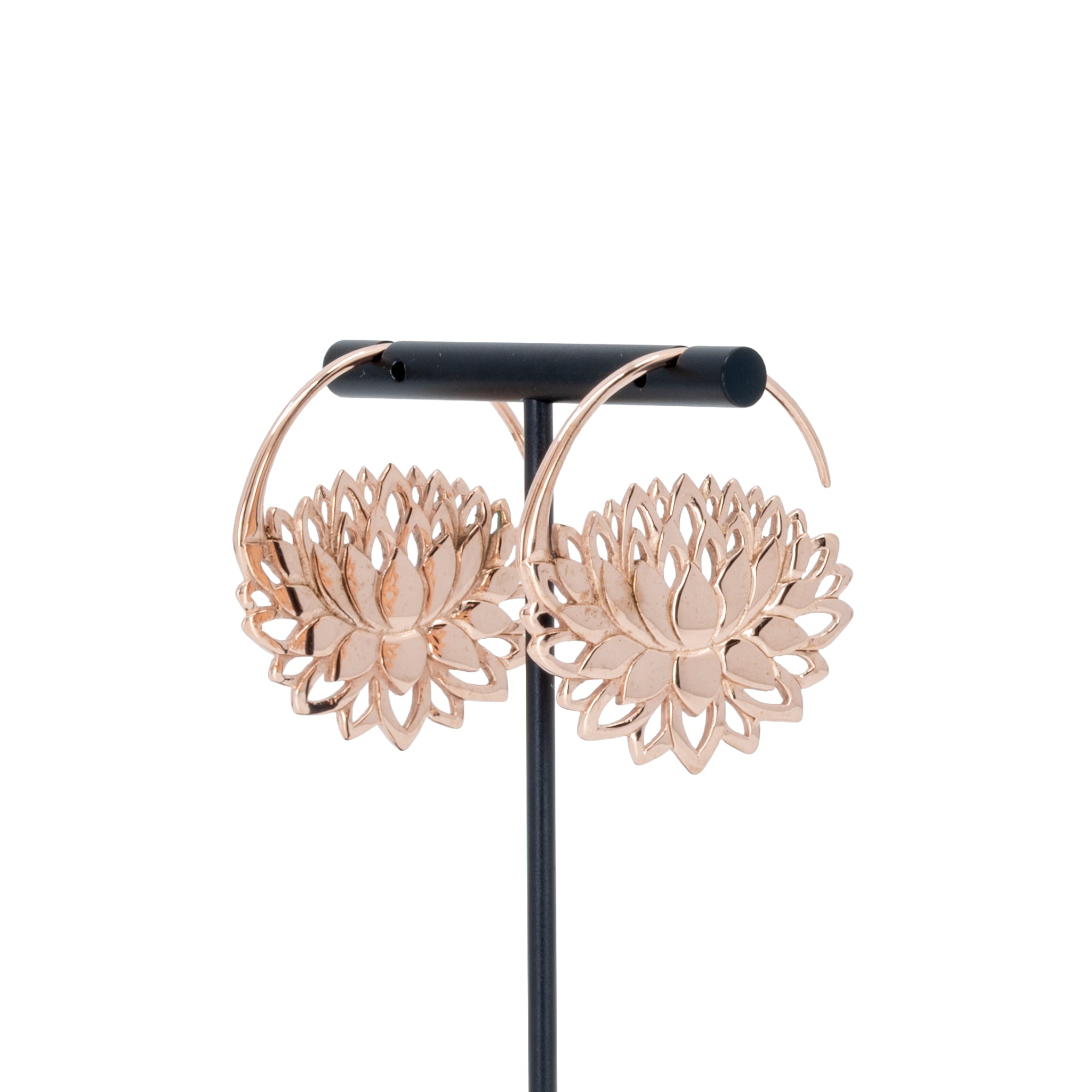A pair of rose gold plated hoop earrings with a lotus at the bottom.