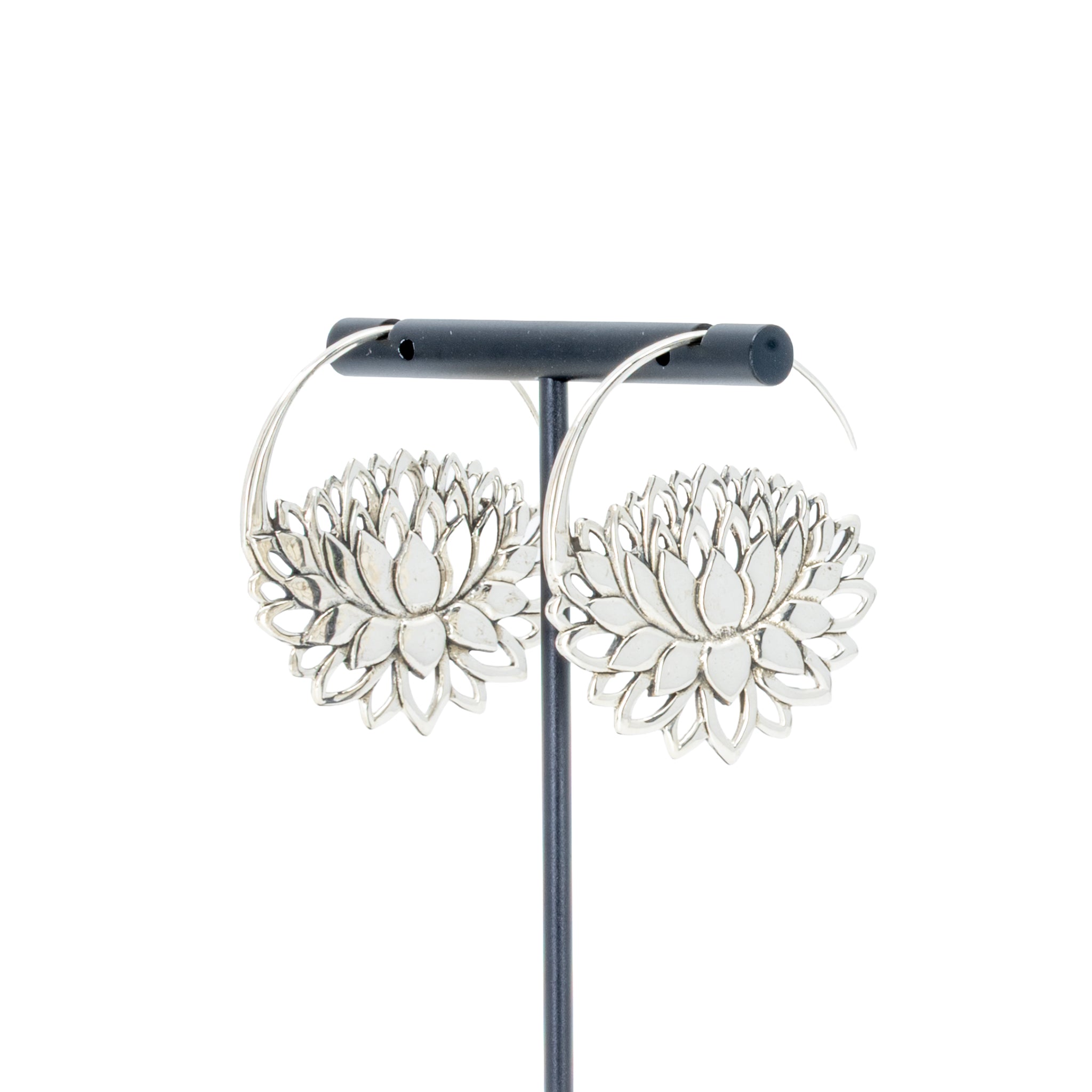 A pair of silver  hoop earrings with a lotus at the bottom.