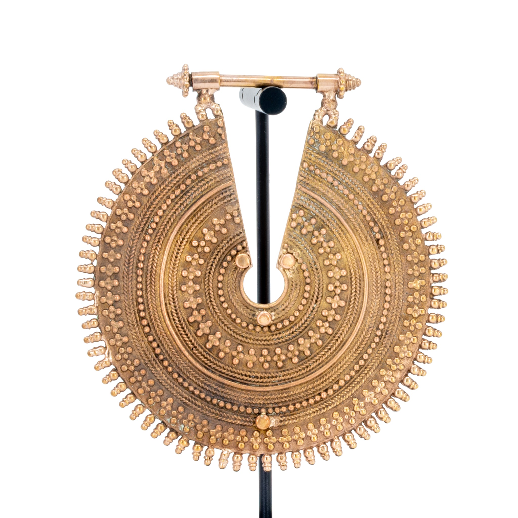 An ornate rose gold weight with intricate concentric beadwork.