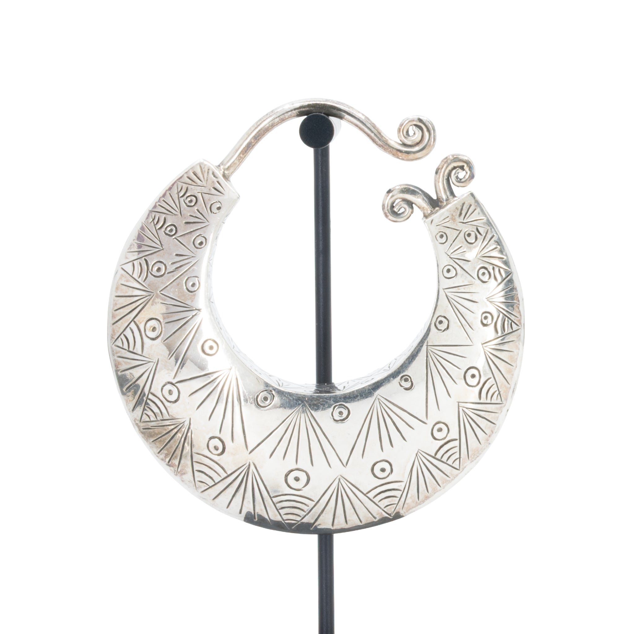 Large silver crescent weight with intricate geometric and sunburst engraved patterns.