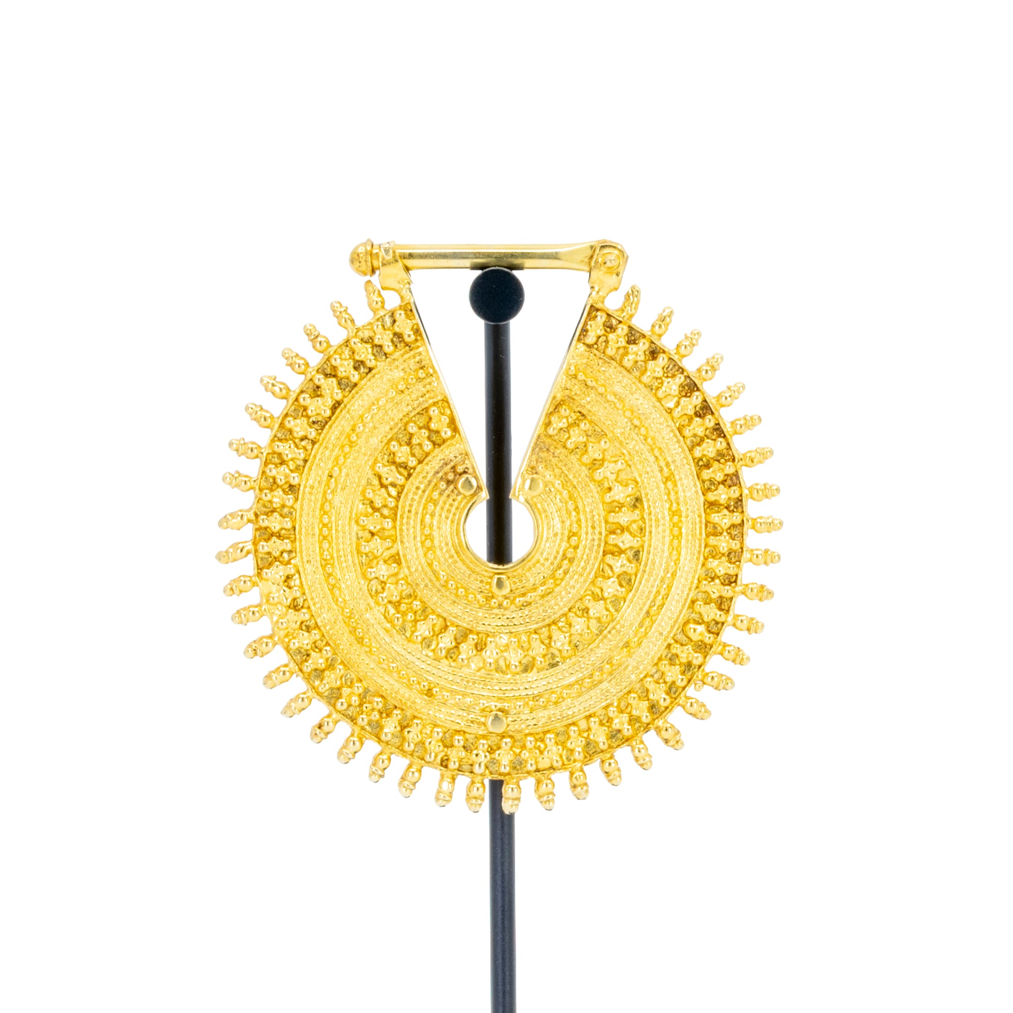An ornate yellow gold weight with intricate concentric beadwork.