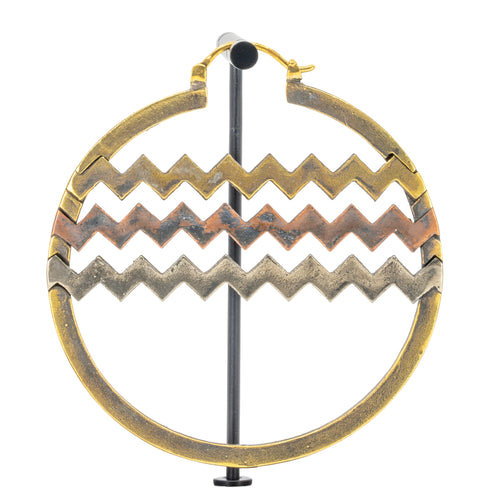 A large hoop earrings with horizontal bands of alternating brass, copper, and white brass chevron cutouts.